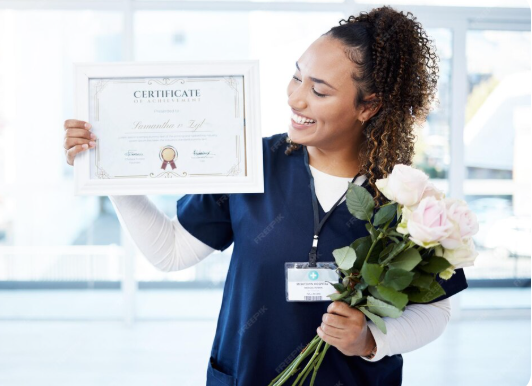 moça trabalhadora exibe um certificado de capacitação . Ela segura o certificado em uma das mãos e, na outra, traz um buquê de rosas brancas