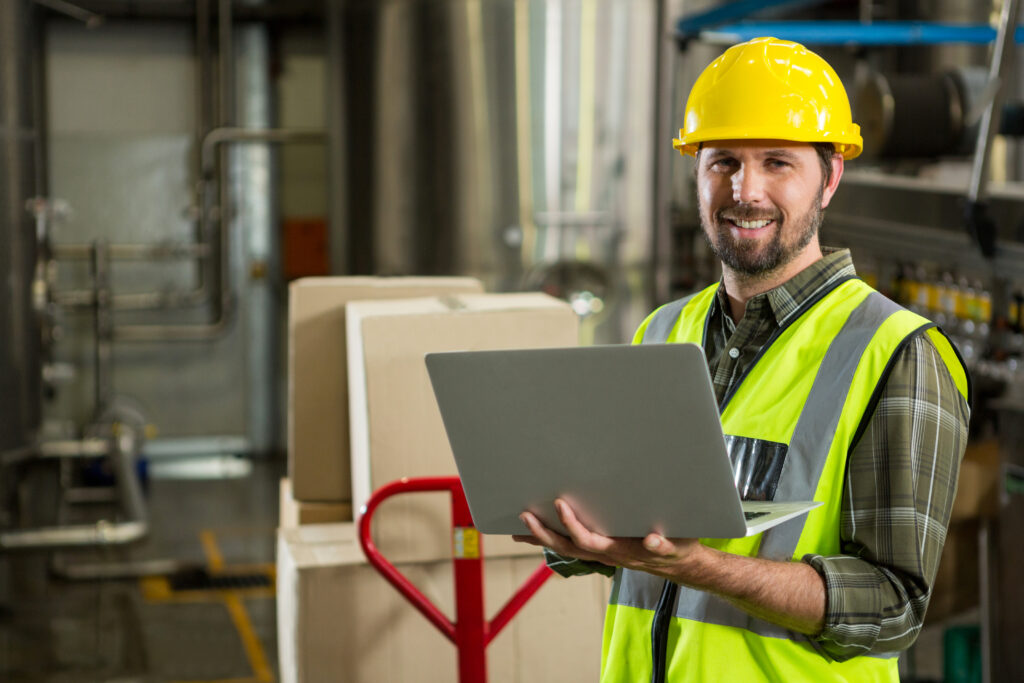 Mercado de trabalho exige qualificação profissional. Na foto, trabalhador com computador nas mãos em um galpão de logística